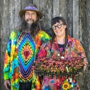 A couple shows off their tie-dye outfits with plants at the Baker Creek Spring Planting Festival.