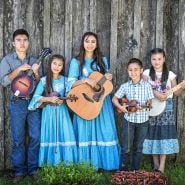 A family bluegrass band poses with their instruments at the Baker Creek Spring Planting Festival.