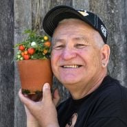 A speaker at the Baker Creek Spring Planting Festival smiles with a little tomato plant.