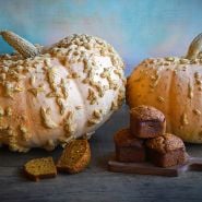 Galeux D' Eysines Winter Squash with pumpkin muffins on wood with light blue background.