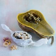 A halved Ayote Green Flesh Winter Squash with baked squash wrapped in pastry paper on light background.