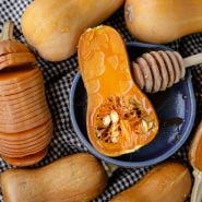 Roasted Honeynut Butternut Winter Squash with honey on a checkered kitchen cloth.