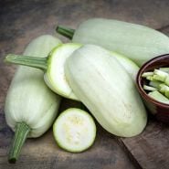 Whole and sliced Odessa Summer Squash arranged on a rustic background.