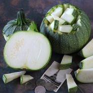 Cut and chopped Ronde De Nice Summer Squash with an image of the Eiffel Tower on dark background.