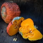 Whole and sliced Essex Hybrid Winter Squash on a wooden background.