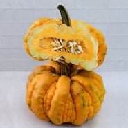 A cut and whole Guicoy Winter Squash stacked on a light background.