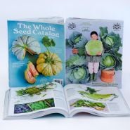 A trio of Whole Seed Catalogs showing the front and back covers with one catalog open.