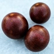 A close-up of a trio of Black Cherry tomatoes on a light background.