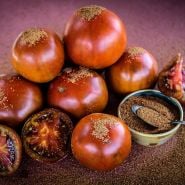 Brown Sugar Tomatoes with brown sugar sprinkled on a deep red background.