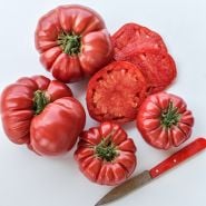 Cut and whole German Pink Tomatoes on light background.