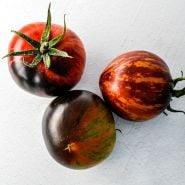 Three Queen of the Night tomatoes on white background.