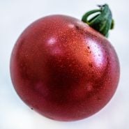 A macro close-up of a single Rosella Tomato on white background.
