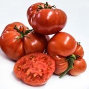 A side view of Pantano Romanesco Tomatoes stacked and cut on a white background.