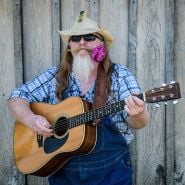 A musician with a tulip in his mouth at the Baker Creek Tulip Festival.