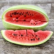 Charleston Gray Watermelon sliced on wooden background.