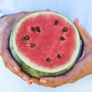 Hands holding a sliced Katanya Watermelon.