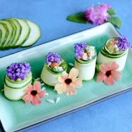 NImba Zucchini Summer Squash vegetarian sushi with flowers on blue background.