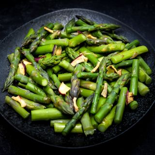 An aparagus salad made with Marry Washington Asparagus on a dark background.