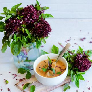 A vase full of Cardinal Basil blooms with curry in a bowl on light background.