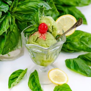 A close-up of Genovese Basil with a glass dish full of basil sorbet.