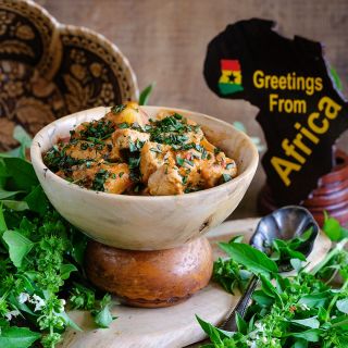 Akoko Mesa Basil tofu recipe in a wooden bowl with fresh basil and props from Ghana.