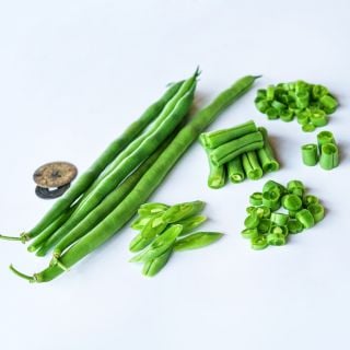 Cut, sliced and whole Jade Bush Beans on a white background.
