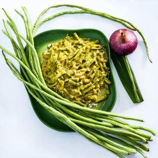 Taiwan Yard-Long Bean Sri Lankan Curry on green plate with fresh long beans on a white background.