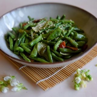 A bowl of cooked McCaslan 42 Pole bean. Prepared chopped with sesame seeds sprinkled on top. 