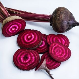 Sliced and whole Betina Beets on a white background.