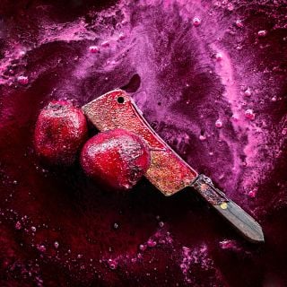 A couple of Bull's Blood Beets with abutcher knife in a river of beet juice.