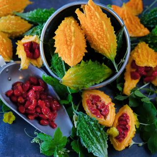 Siamese Bitter Melons in a bowl with seeds and vines.