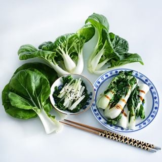 Fresh and cooked Baby Milk Bok Choy arranged on a white background.