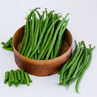 Chopped and whole uniformly straight Odeon Bush Beans in a wooden bowl on a white background.