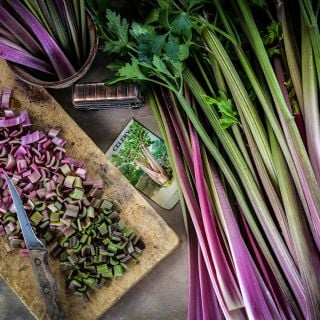 Giant Red Celery stalks and slices on a cutting board.