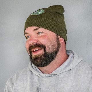 The Baker Creek general manager smiling while wearing a Baker Creek Logo Beanie.