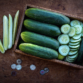 Ancash Cucumber, whole, sliced and speared in crate on wooden background