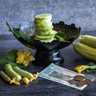 Poona Kheera Cucumbers on in stand with gray background.