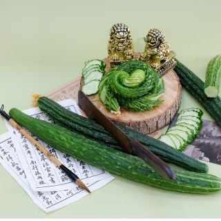 Suyo Long Cucumber sliced in spiral on wooden slab.