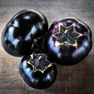 Three Qi Ye Round Eggplants on a wooden background.