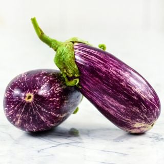 Listada De Gandia Eggplants on marble counter top.