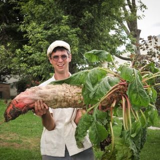 Jere Gettle with a Mammoth Red Mangel Beet at the Baker Creek Farm.
