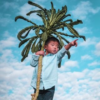 Cyan holding Nero Di Toscana pointing into distance with sky background