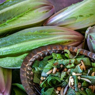 A close-up of Brown Goldring Lettuce heads and a salad with toppings.