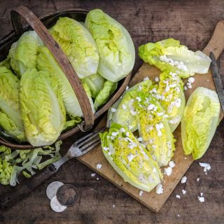 A basket of Little Gem Lettuce with some cut-ups on a wood board.