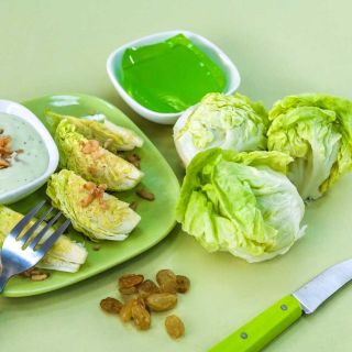 Tom Thumb Lettuce heads on table top next to a plate of quartered lettuce heads and a bowl of jello.