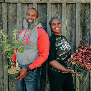 A couple of speakers pose with plants at the Baker Creek Spring Planting Festival.