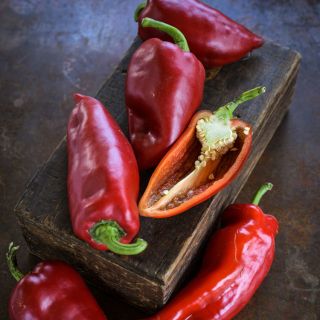 Ajvarski Sweet Peppers on a wooden box on a dark background.