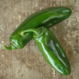 Two Nadapeño Sweet Peppers on a wooden background.
