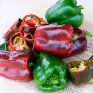 A pile of green and red Ozark Giant Peppers on top of a Springfield, Missouri newspaper.