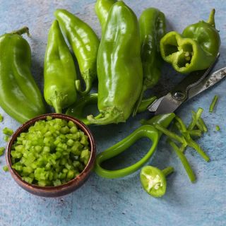 Anaheim Peppers, julienned and diced on blue background.